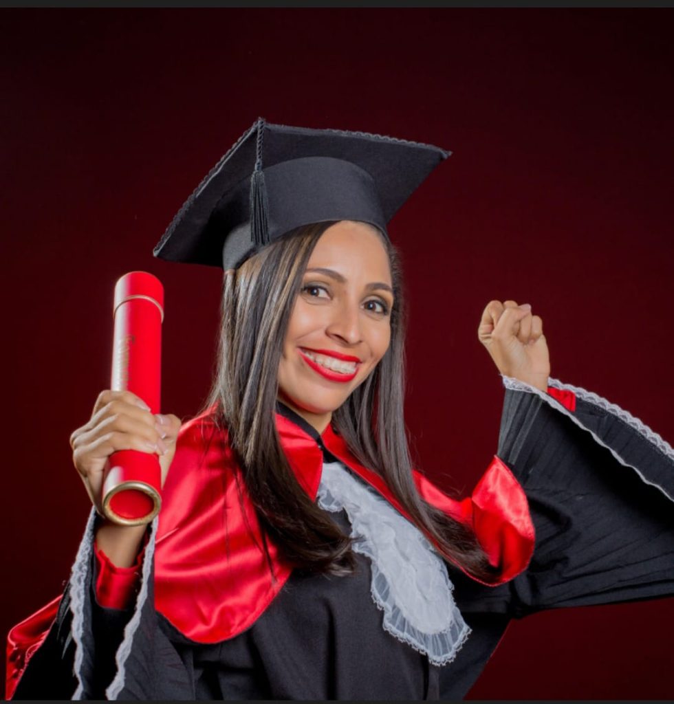 Mostra uma mulher vibrando com sua formatura em Direito
