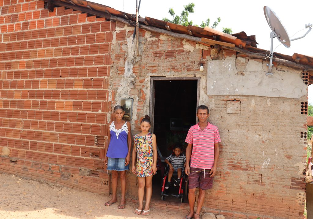 Familia em frente a casa onde moram