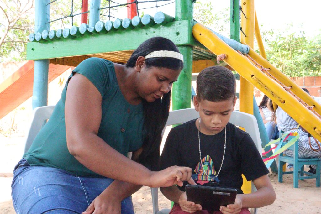 Educadora orienta criança, em oficina de informática do ChildFund. Importante para ECA Digital